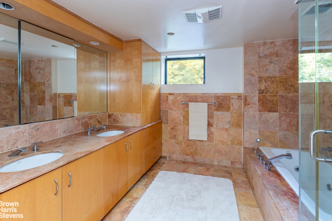 712 Ladd Road Bronx, NY 10471 - Photo 18 of 34 a bathroom with a granite countertop sink mirror and a bath tub