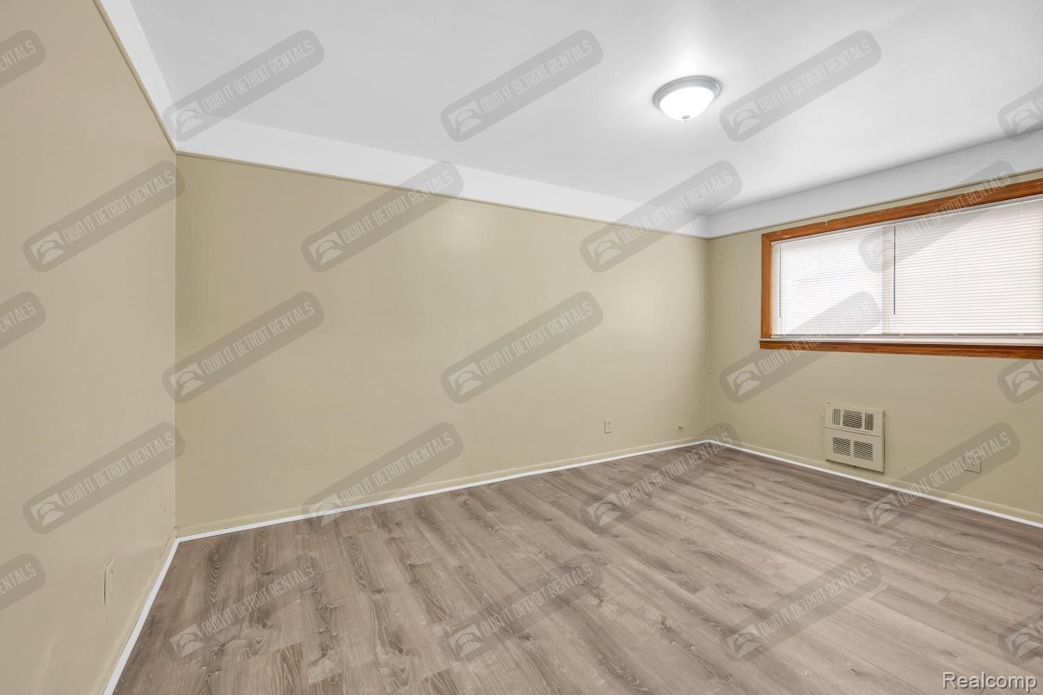 16721 Greenfield Road, Unit 5 Detroit, MI 48235 - Photo 11 of 18 Empty room featuring baseboards and wood finished floors