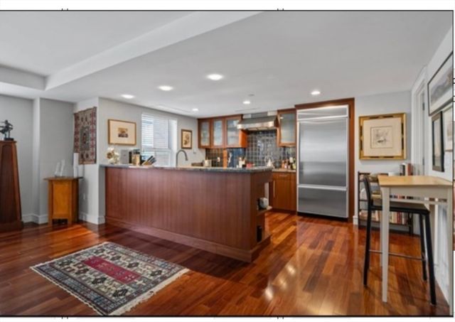 a kitchen with stainless steel appliances granite countertop a refrigerator and a stove