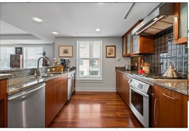 a kitchen with stainless steel appliances granite countertop a sink stove and cabinets