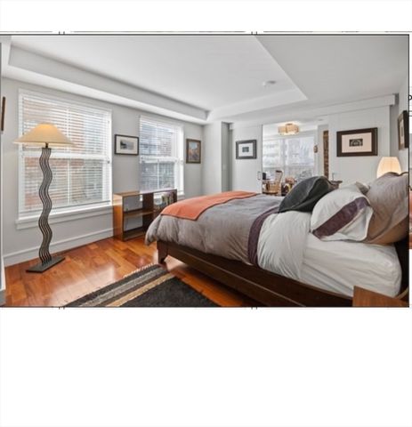 a living room with a bed furniture and next to a window