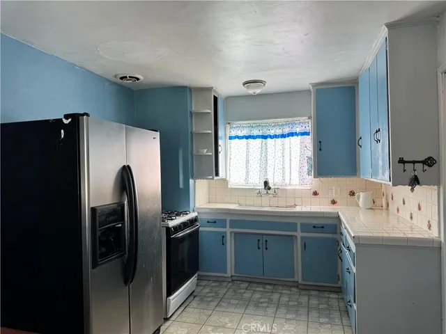 a kitchen with stainless steel appliances granite countertop a refrigerator and a sink