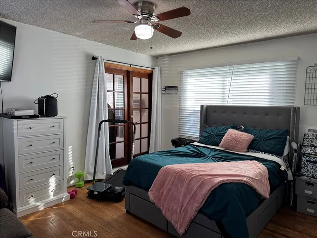 a bedroom with a bed and a flat tv screen on the dresser