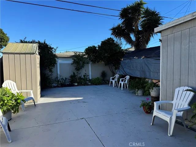 a view of backyard with outdoor seating and plants