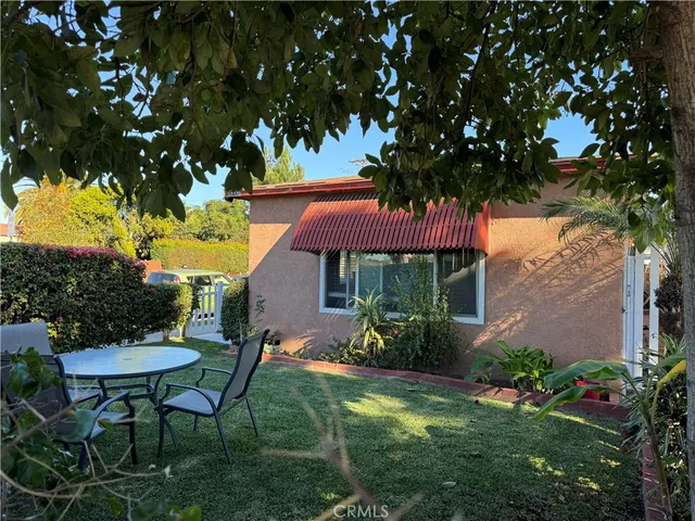 a view of a chair and table in backyard of the house