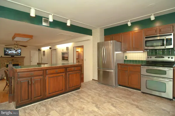 a kitchen with stainless steel appliances granite countertop a refrigerator and a stove top oven
