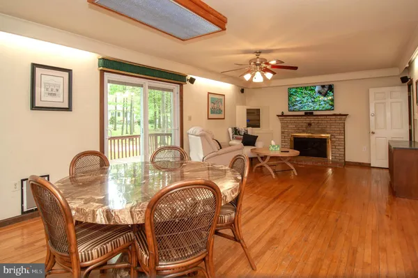 a dining room with furniture a fireplace and wooden floor