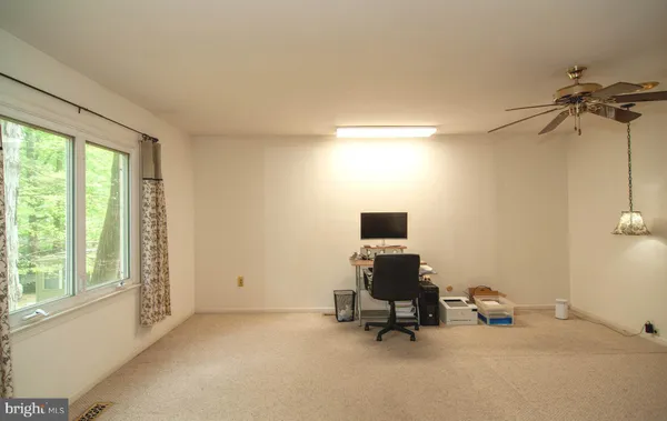 a view of a workspace with furniture and a window