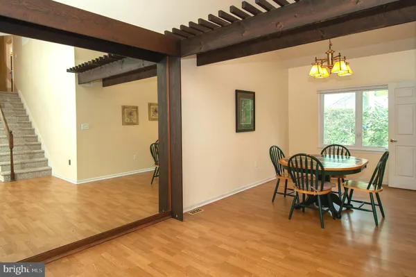 a view of a dining room with furniture a chandelier and wooden floor