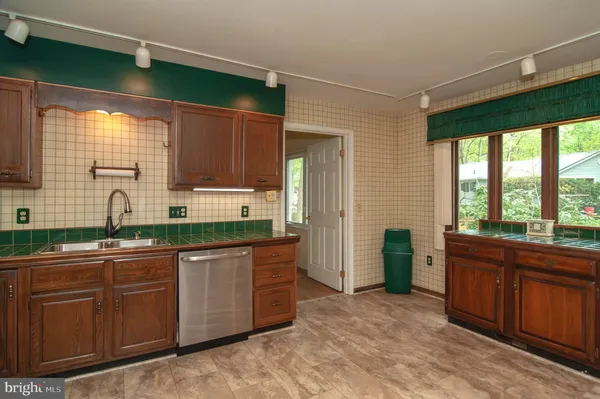 a kitchen with stainless steel appliances granite countertop wooden cabinets a sink and a large window