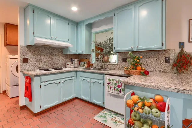 a view of a dining room with furniture a chandelier and large windows