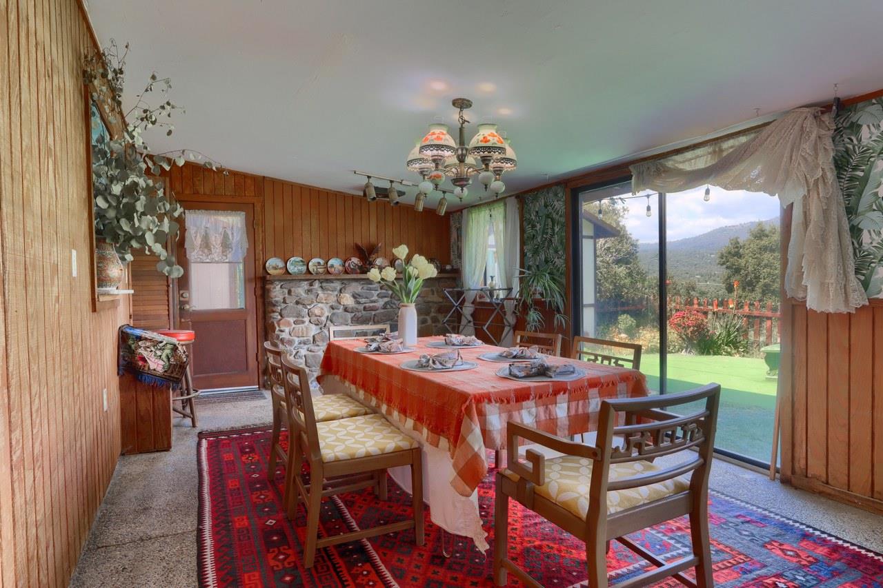 44800 Ahwahnee Acres Road Ahwahnee, CA 93601 - Photo 16 of 77 a view of a dining room with furniture a chandelier and large windows
