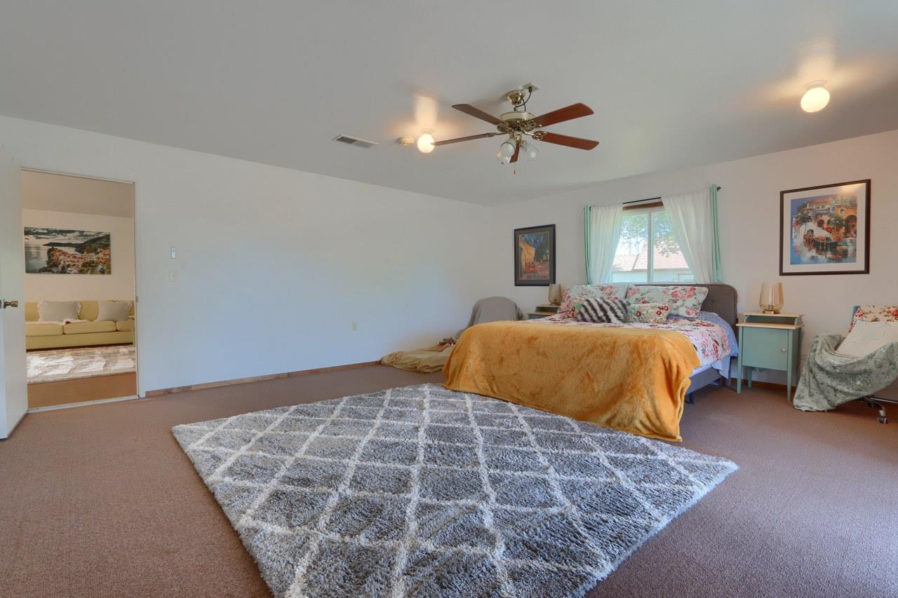44800 Ahwahnee Acres Road Ahwahnee, CA 93601 - Photo 27 of 77 a bedroom with a large bed and a chandelier