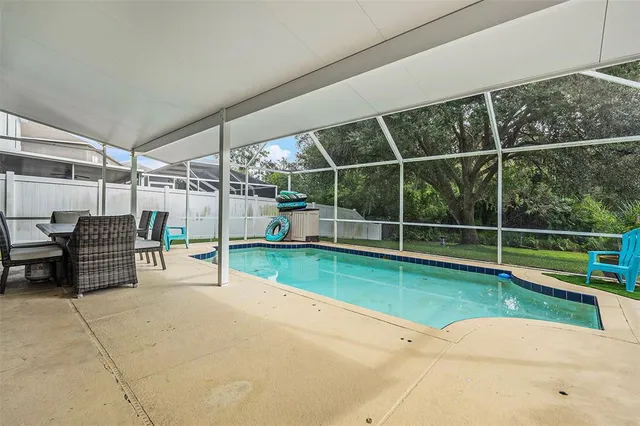 a view of a swimming pool with lawn chairs and a umbrella