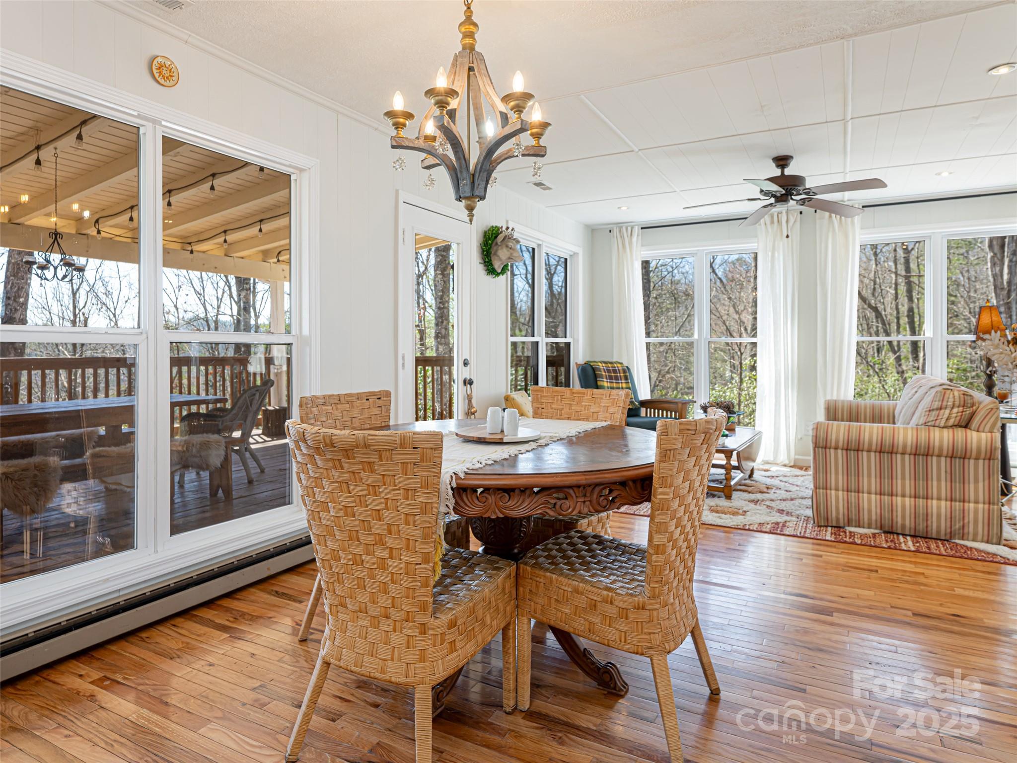 75 Deep Woods Road Mills River, NC 28759 - Photo 11 of 48 a dining room with wooden floor a chandelier a glass table and chairs