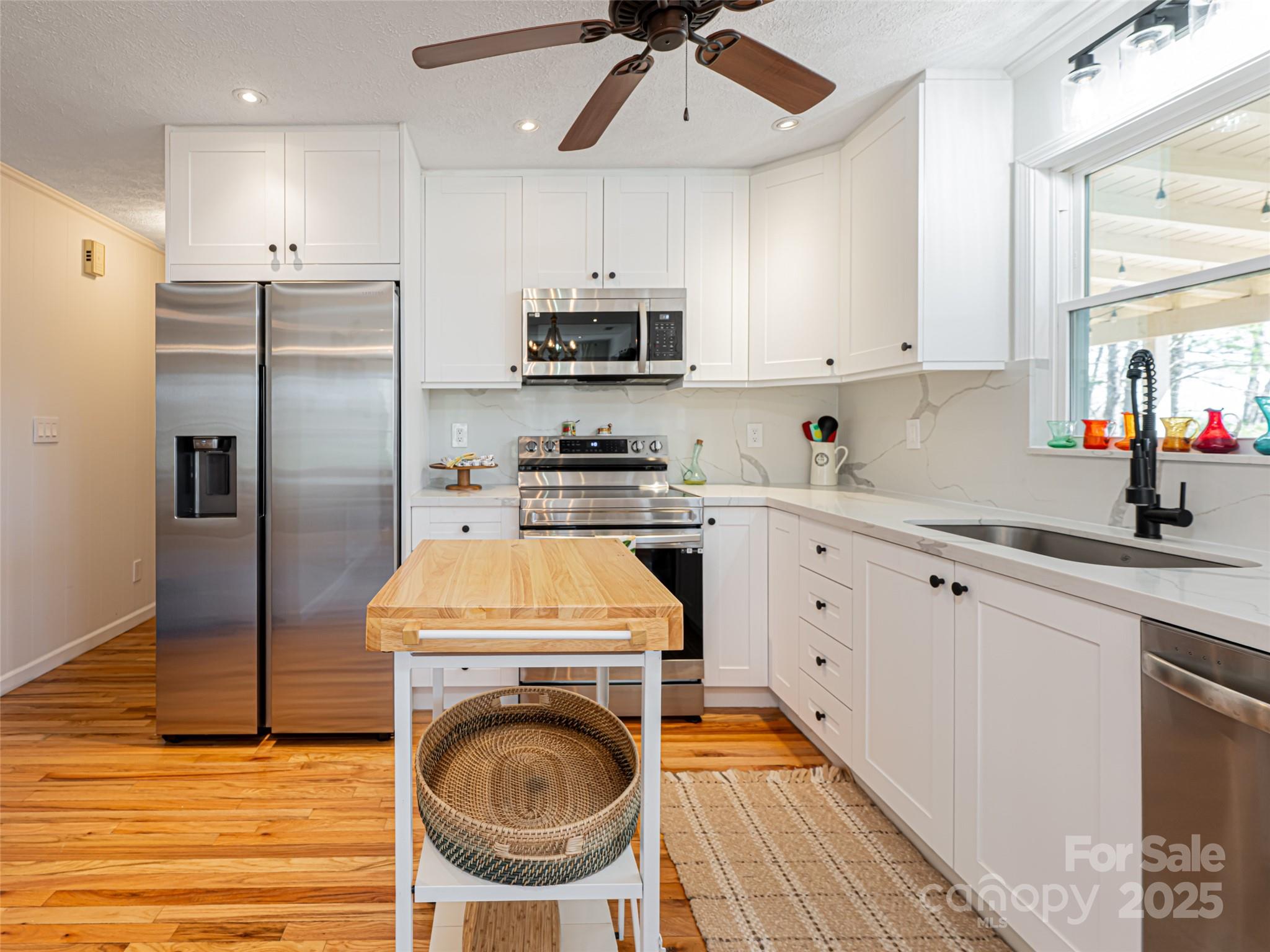 75 Deep Woods Road Mills River, NC 28759 - Photo 13 of 48 a kitchen with stainless steel appliances granite countertop a sink a stove a refrigerator and island with wooden floor