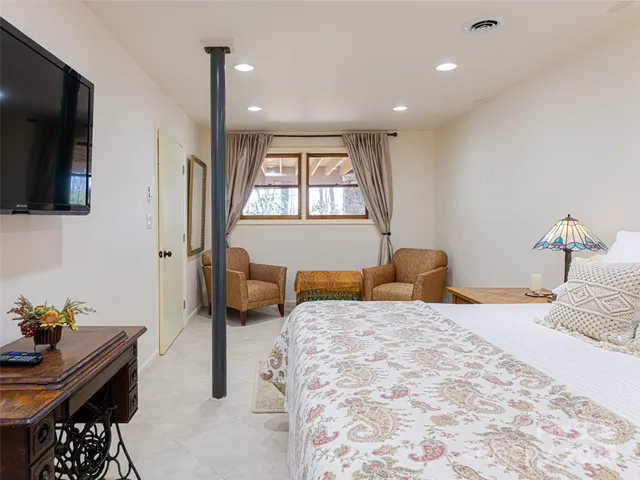 a bedroom with a bed a flat screen tv and a couch