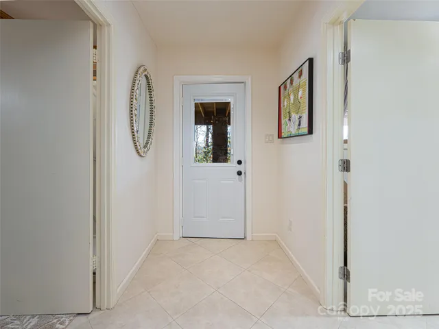 a view of a hallway with wooden floor and a white door