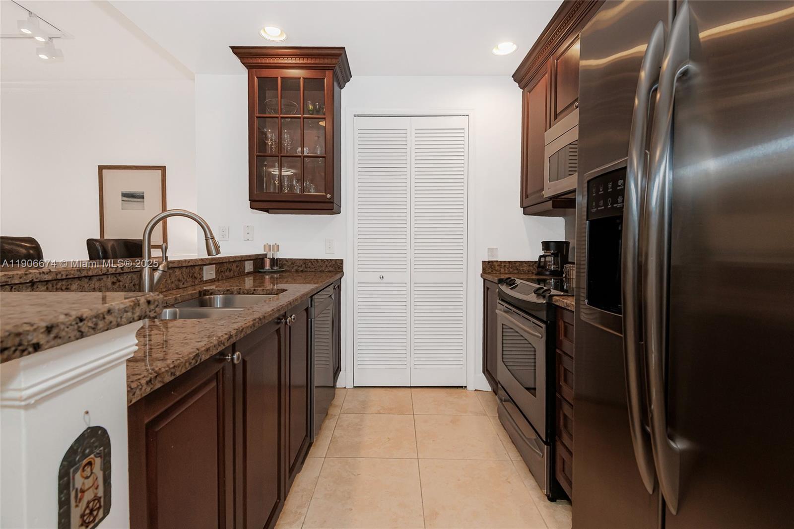 100 Andalusia Avenue, Unit 210 Coral Gables, FL 33134 - Photo 11 of 29 a kitchen with a sink stove and refrigerator