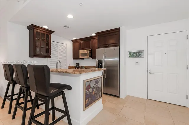 a kitchen with stainless steel appliances granite countertop a refrigerator and a stove top oven