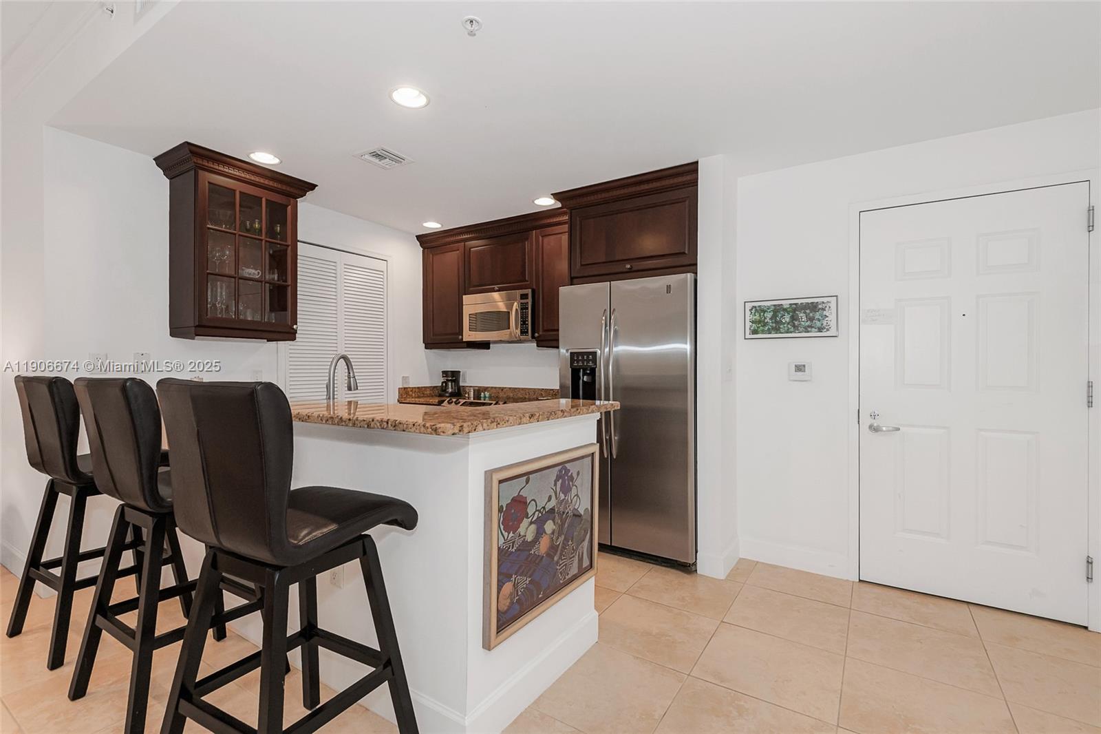 100 Andalusia Avenue, Unit 210 Coral Gables, FL 33134 - Photo 8 of 29 a kitchen with stainless steel appliances granite countertop a refrigerator and a stove top oven