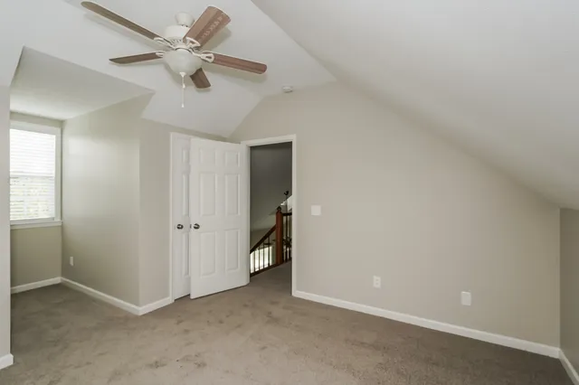 an empty room with a ceiling fan and a window