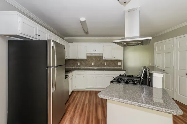 a kitchen with stainless steel appliances granite countertop a refrigerator and a stove