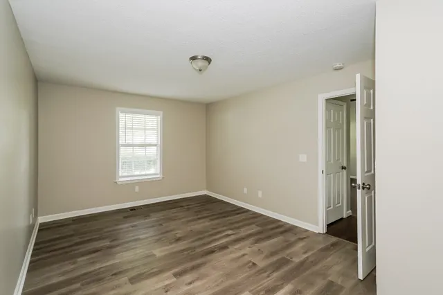 a view of a room with wooden floor and window