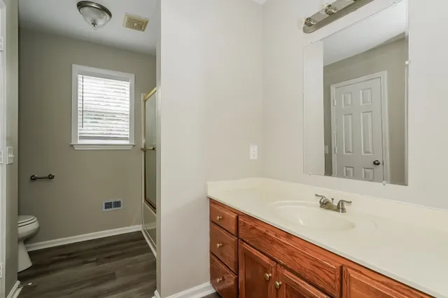 a bathroom with a sink a toilet and a window