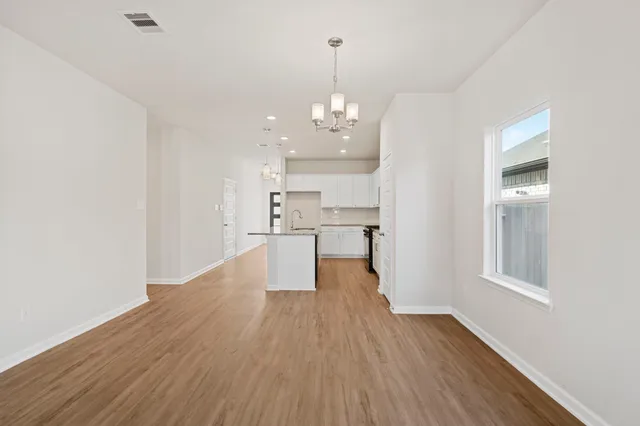 a view of a kitchen with wooden floor and a window