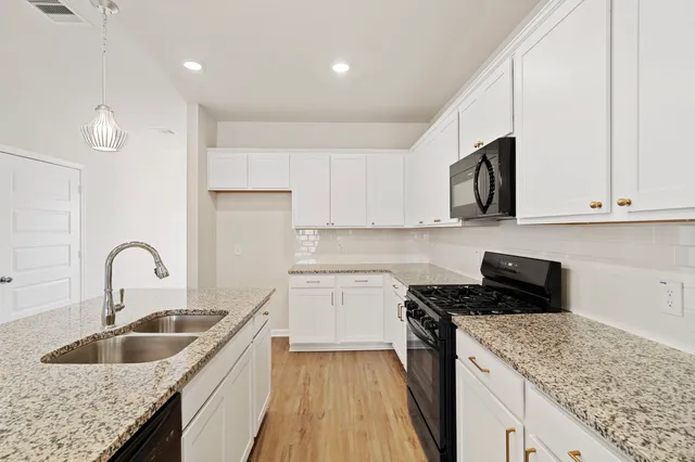 a kitchen with stainless steel appliances granite countertop a sink stove and microwave