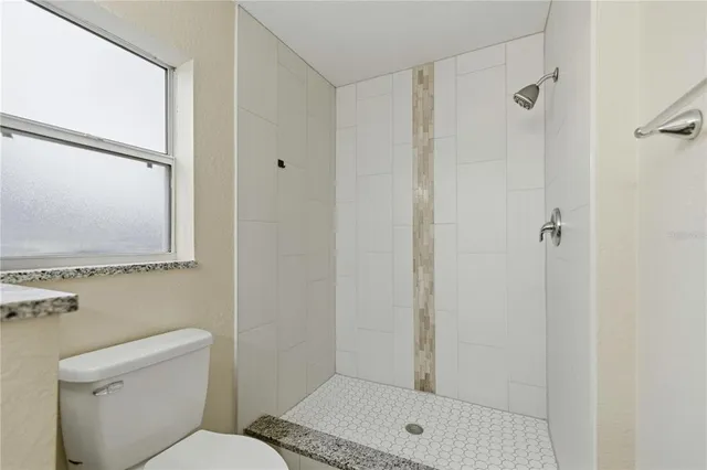 a bathroom with a toilet and a shower