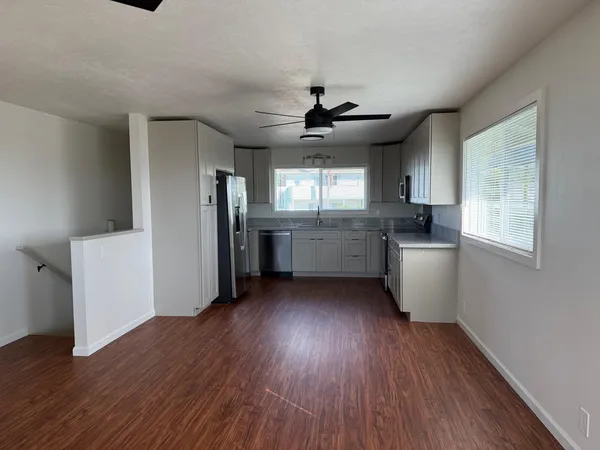 a kitchen with stainless steel appliances granite countertop a hardwood floor sink stove and granite counter top