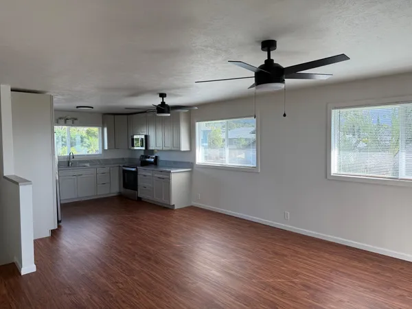 a kitchen with stainless steel appliances granite countertop a sink cabinets and wooden floor