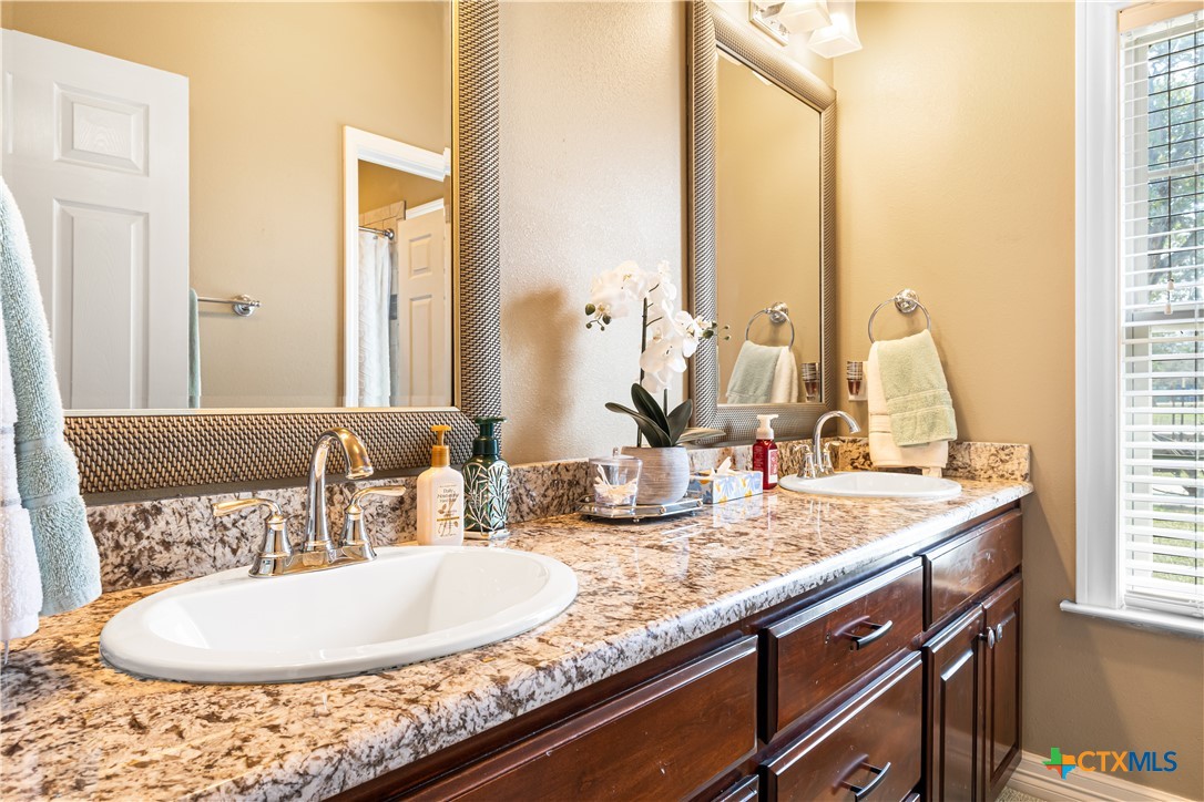 790 Spanish Grant Road Goliad, TX 77963 - Photo 26 of 41 a bathroom with a granite countertop sink and a mirror