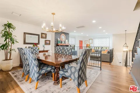 a dining room with furniture a chandelier and wooden floor