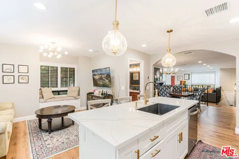a large white kitchen with a large window and stainless steel appliances