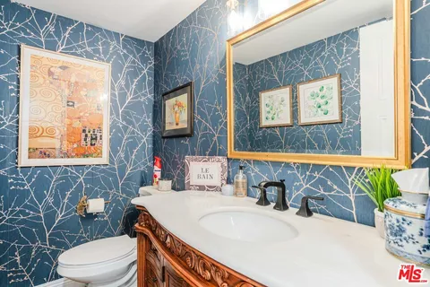 a bathroom with a sink a toilet and mirror