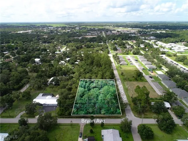 an aerial view of residential houses with outdoor space and trees