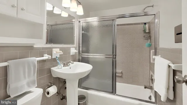 a bathroom with a sink mirror toilet and shower