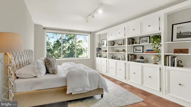 a bedroom with bed and white cabinets