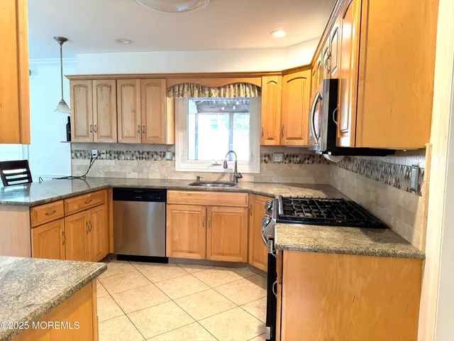 a kitchen with stainless steel appliances granite countertop a sink stove and cabinets