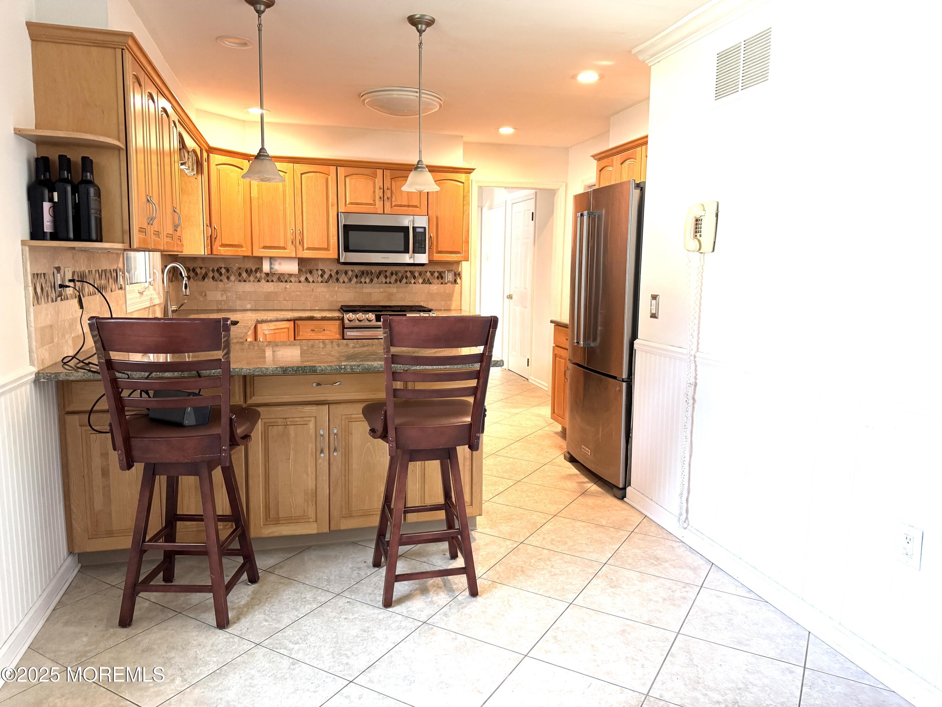 28 Ridge Road West Long Branch, NJ 07764 - Photo 2 of 8 a kitchen with stainless steel appliances kitchen island granite countertop dining table chair and a granite counter tops