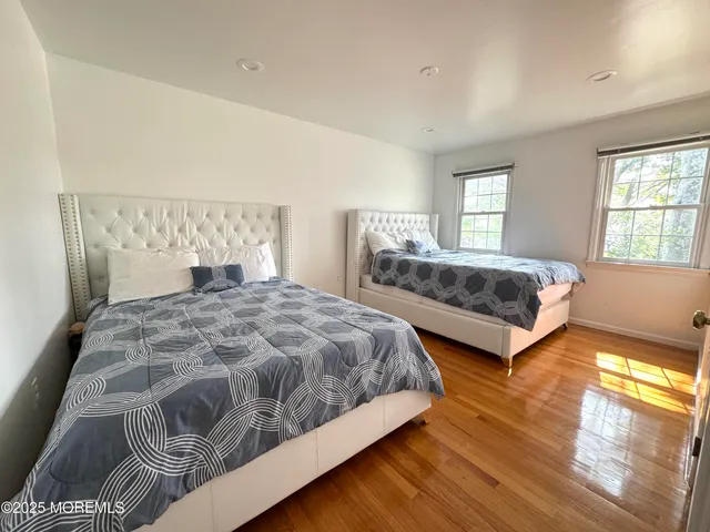 a spacious bedroom with a bed and wooden floor