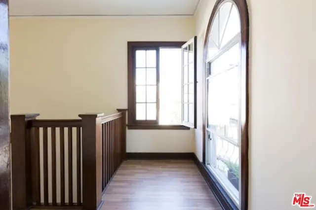 a view of a hallway with wooden floor and staircase