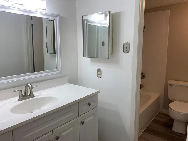a bathroom with a sink mirror vanity and toilet