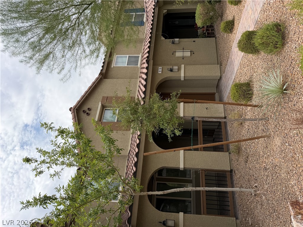 916 Riggs Flats Avenue North Las Vegas, NV 89086 - Photo 6 of 43 Elegant exterior architecture showcases arched entryways and classic Spanish tile roofing elements.