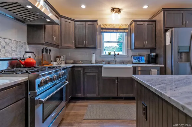 a kitchen with stainless steel appliances granite countertop a sink stove and refrigerator