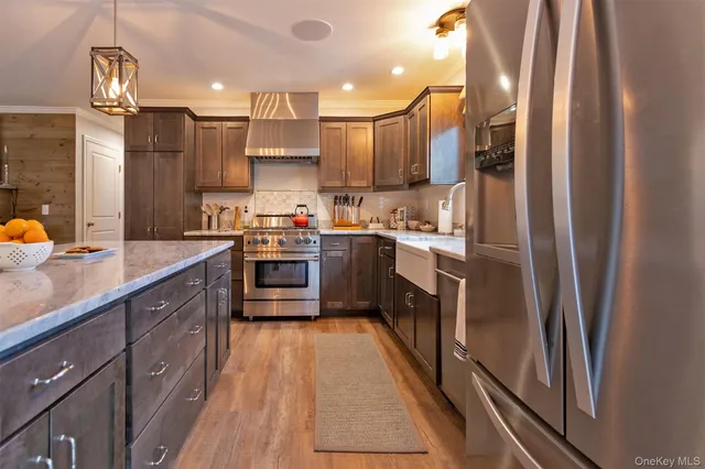 a kitchen with stainless steel appliances a sink stove and refrigerator