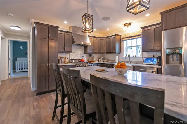 a kitchen with stainless steel appliances granite countertop a table chairs sink refrigerator and microwave